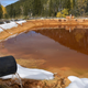 Water contaminated with arsenic, lead, and zinc flowing from a pipe out of the Lee Mountain mine and into a holding pond near Rimini, Montana. The pond is part of the Upper Tenmile Creek Superfund site.